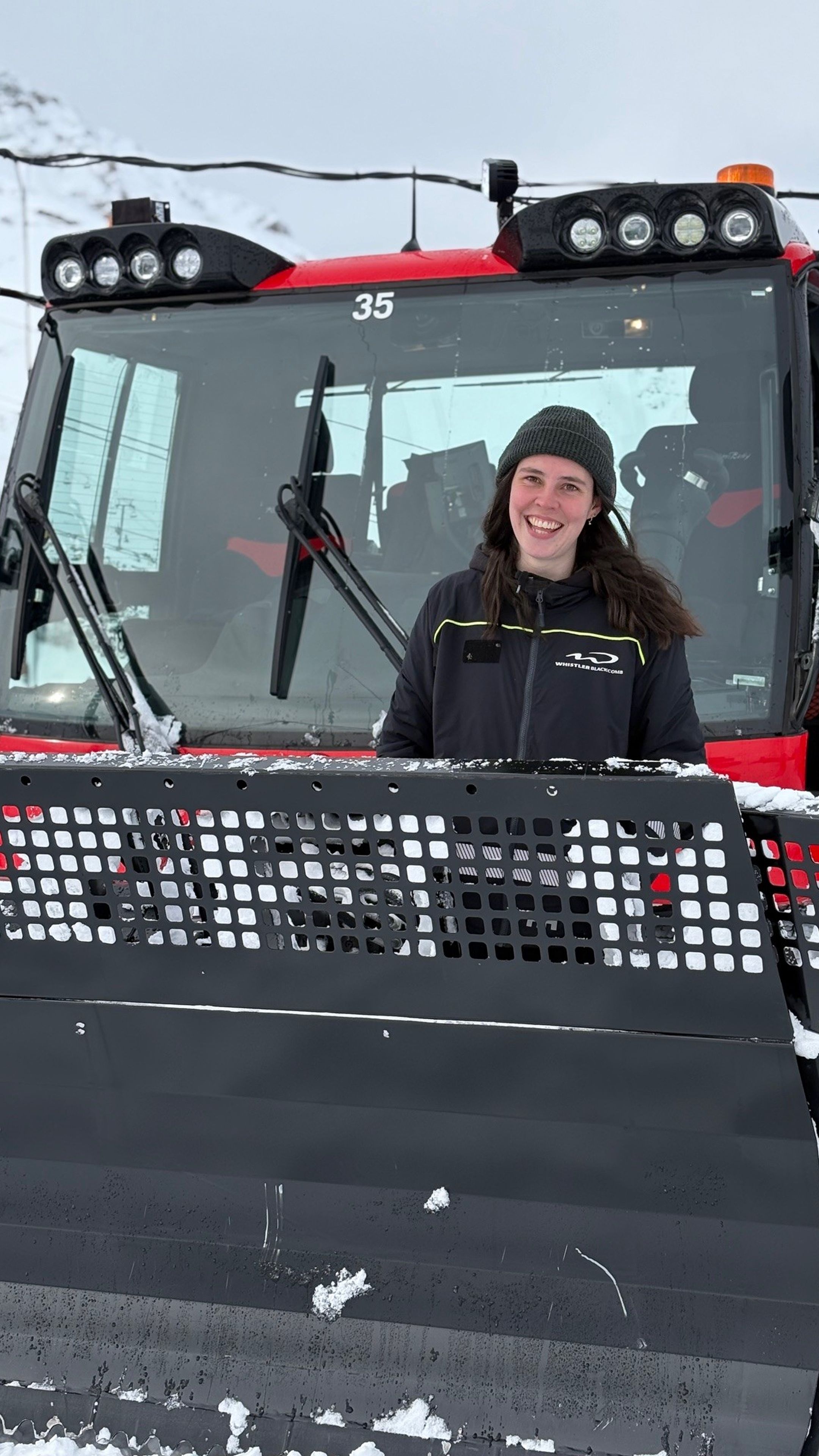 Teagan Atherstone in front of her PistenBully.